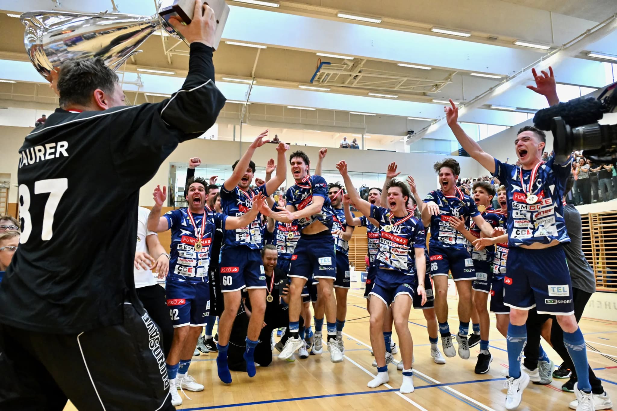 Die Mannschaft des VSV Unihockey jubelt mit dem Meisterpokal
